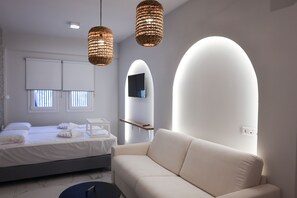 Une chambre à coucher moderne avec un lit, un canapé et deux lampes suspendues en osier.