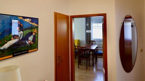 A room with a wooden cabinet, a painting, a door leading to a dining area, and a mirror on the wall. - Strandnahe 2-zimmer-fewo für 3 Personen mit Wlan (Graal-Müritz)