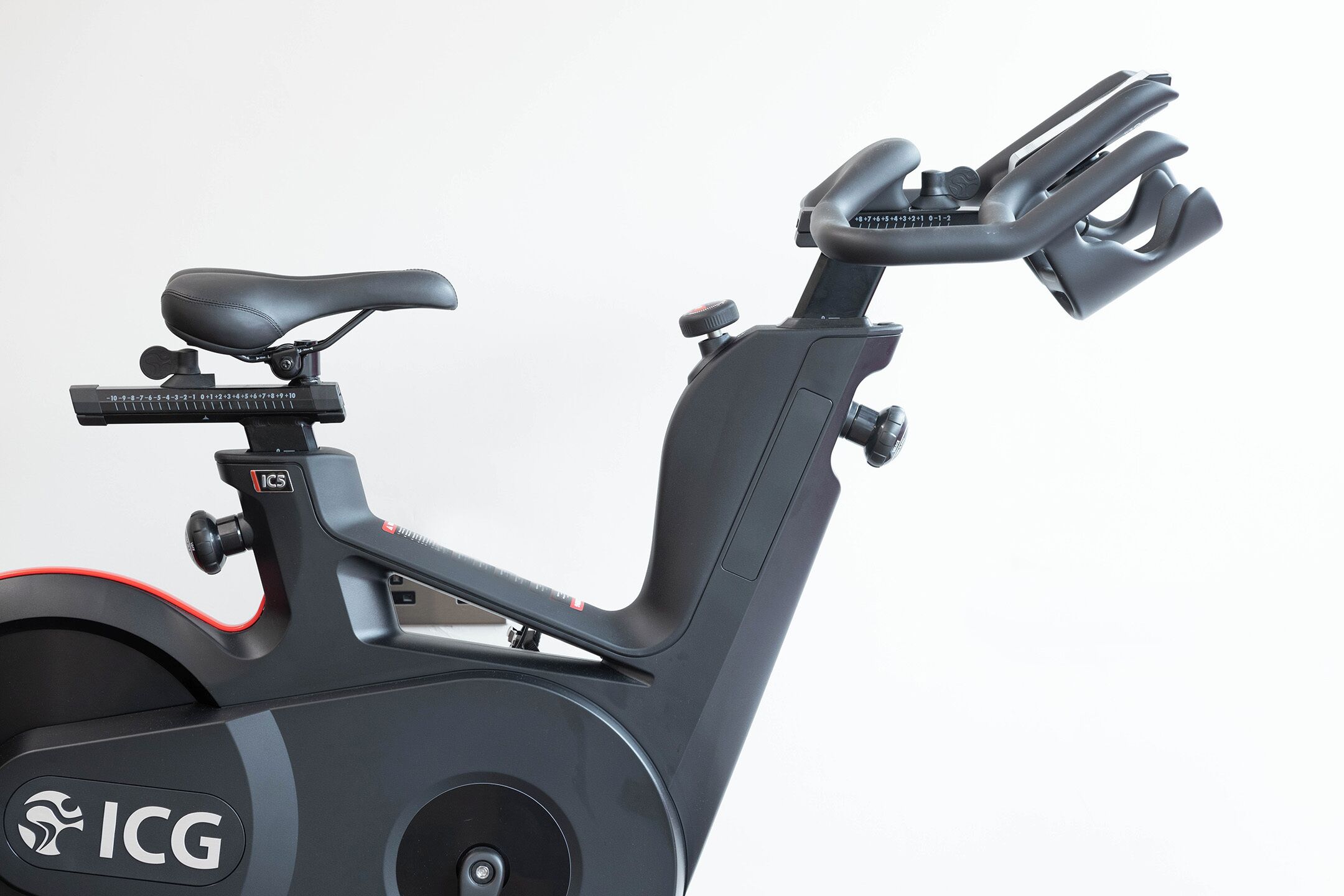 Una bicicleta estática con asiento, manillar y panel de control negros.