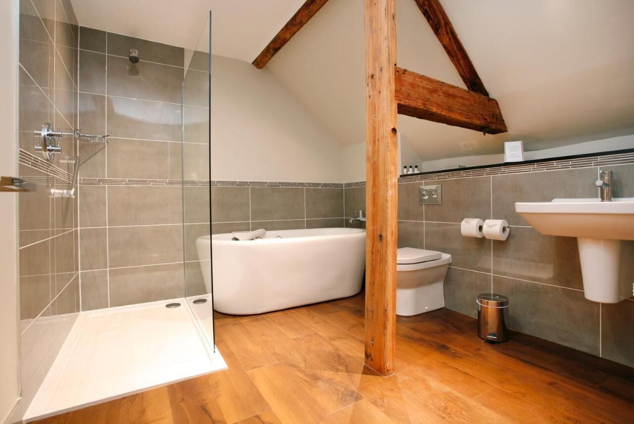 Une salle de bain moderne avec une douche à parois de verre, une baignoire sur pieds, des toilettes et un lavabo.