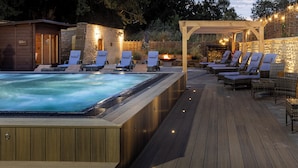 Un área de hidromasaje con sillones de descanso y una pérgola.