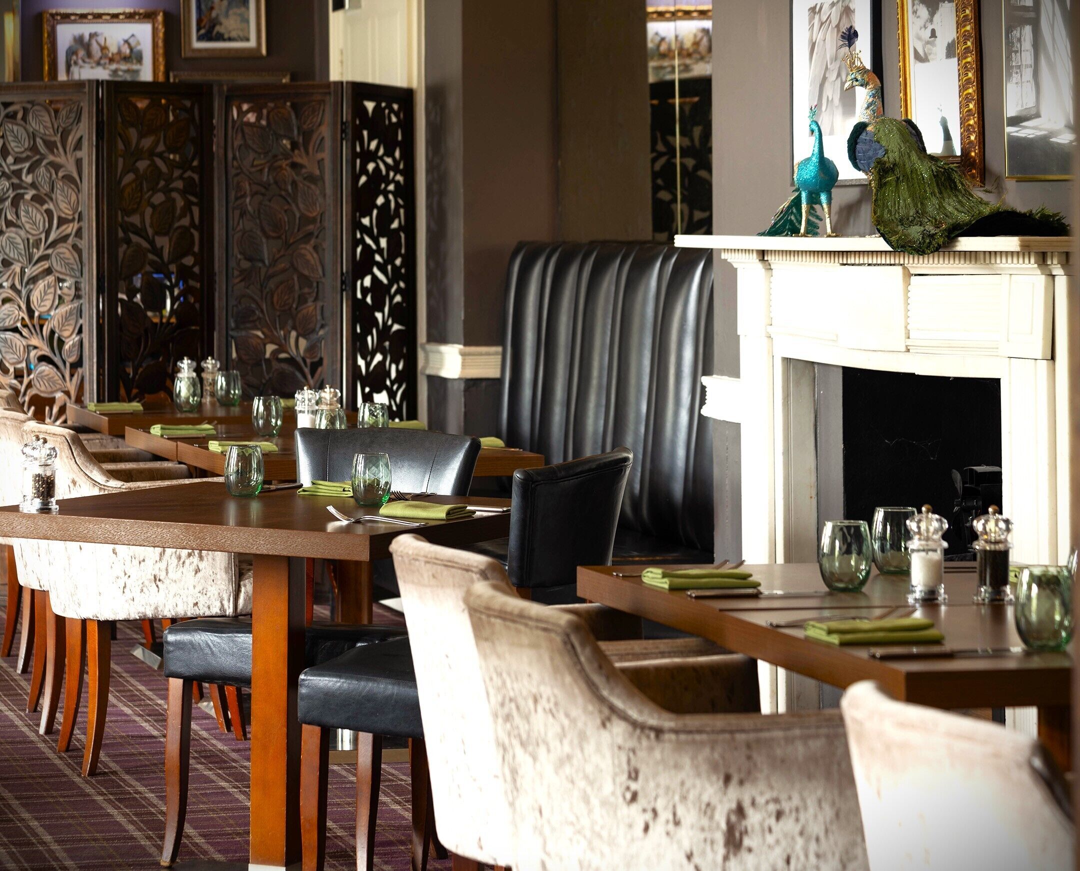 A dining area with a long table, multiple chairs, and a fireplace.