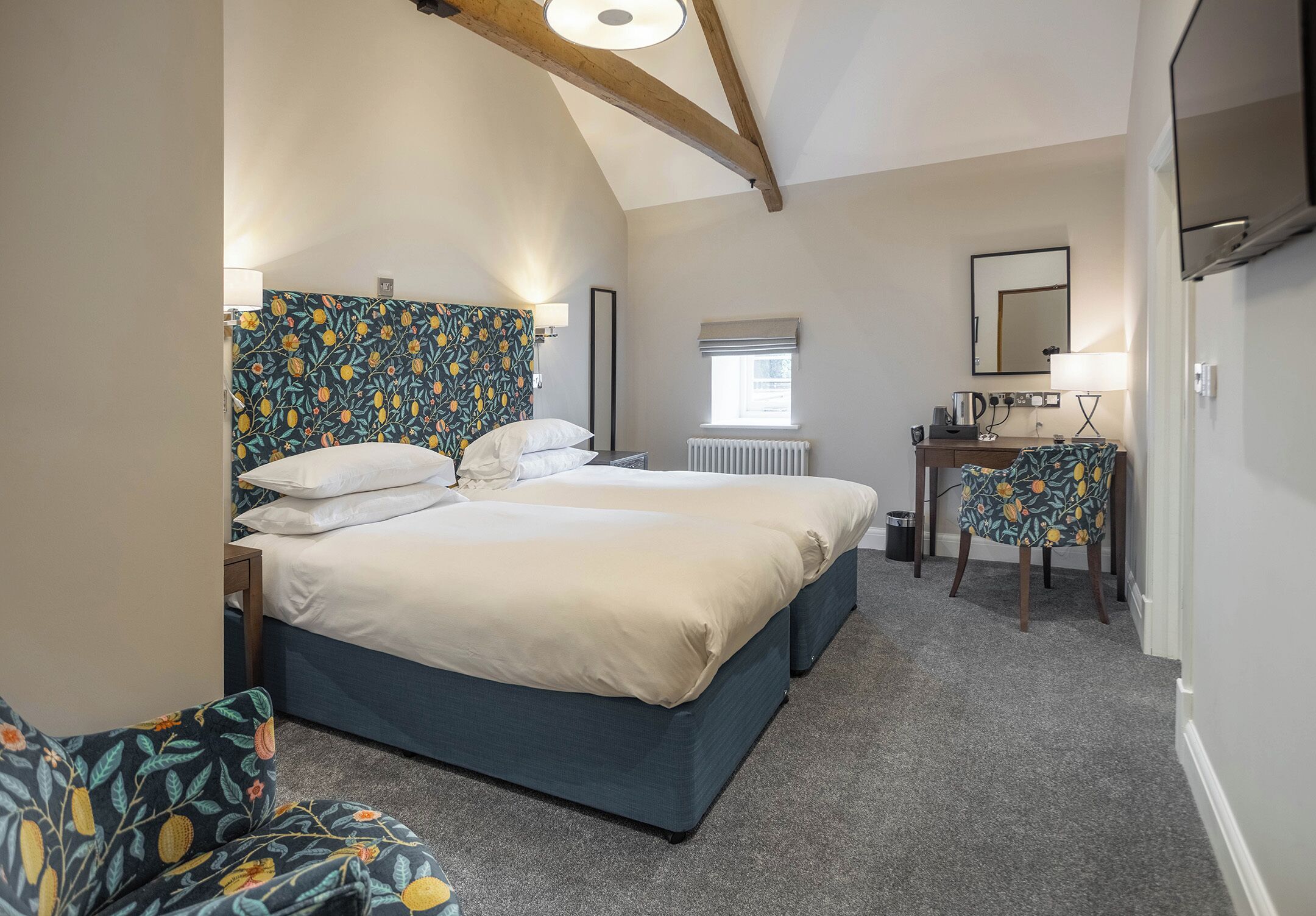 A bedroom with a bed, a desk, a chair, and a radiator.