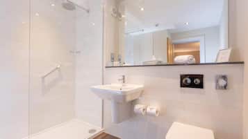 A modern bathroom with a glass shower enclosure, a white sink, and a toilet.