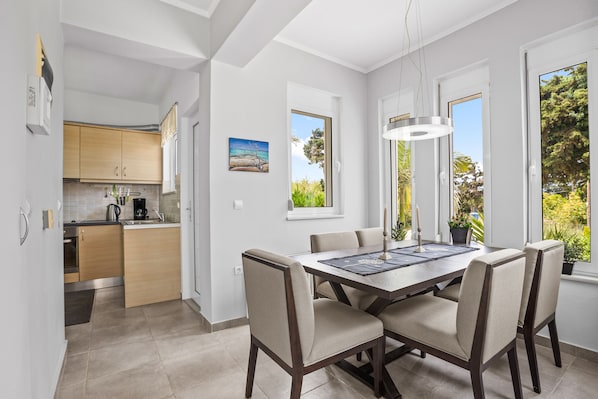 A modern kitchen with wooden cabinets and a dining area with a table and chairs.