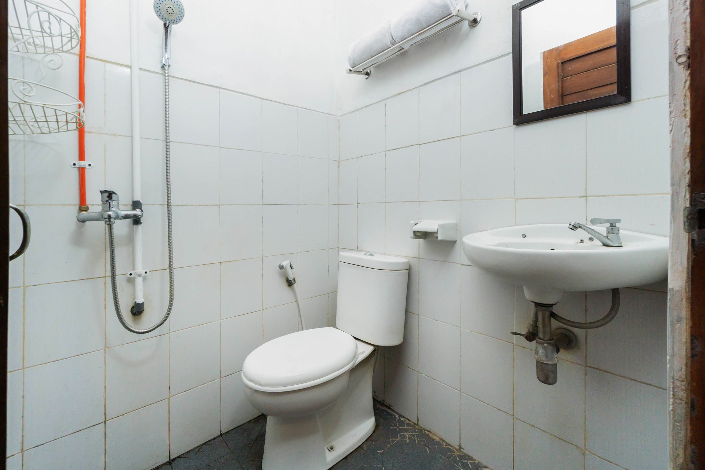 A small bathroom with a toilet, a sink, and a shower.