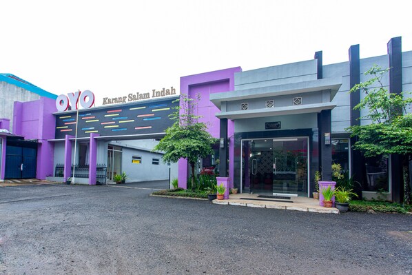 A building with a purple facade and a sign that reads "OYO Karang Sam Indah". - Hotel O Griya Karangsalam Indah (Purwokerto)