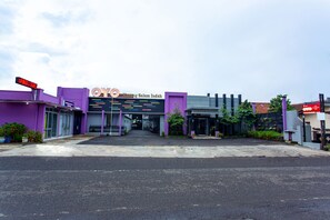 A building with a purple facade and a sign that reads "OYO by Salama Indah". - Hotel O Griya Karangsalam Indah (Purwokerto)