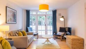 Ein Wohnzimmer mit einer Couch, Sesseln, einem Couchtisch und einer Lampe.