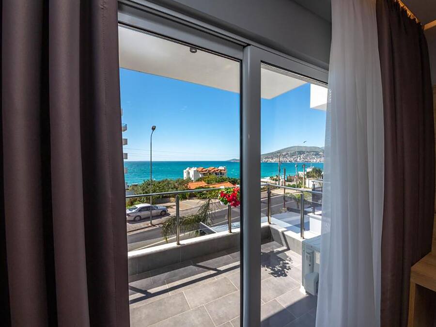 Un balcone con vista sul mare e una città in lontananza.