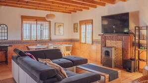A cozy living room with a sofa, a TV, and a fireplace. - Rural House on the Tropical Coast with Salt Pool (Salobreña)
