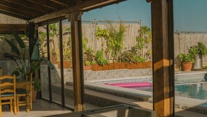 An outdoor patio area with wicker furniture, a pool, and potted plants. - Rural House on the Tropical Coast with Salt Pool (Salobreña)