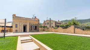 A courtyard with a stone pathway leading to a building with a tiled roof. - Villa Alla Baia dei Sette Emiri by Wonderful Italy (Cefalù)