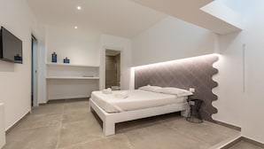 A modern bedroom with a large bed, a TV mounted on the wall, and a walk-in closet. - Villa Alla Baia dei Sette Emiri by Wonderful Italy (Cefalù)