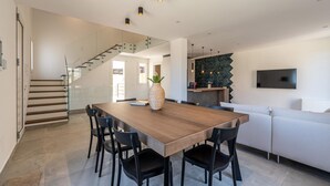 A modern kitchen with a wooden dining table, black chairs, and a herringbone-patterned backsplash. - Villa Alla Baia dei Sette Emiri by Wonderful Italy (Cefalù)