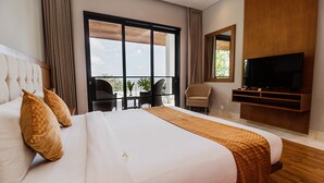 Une chambre d’hôtel avec un grand lit, une télévision et un balcon équipé de chaises.