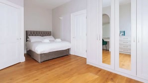 A bedroom with a bed, wardrobe, and a mirror. - Chic & Characteristic 2BD House - Irishtown (Dublin)
