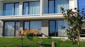 Et moderne hus med to etager, store vinduer og en velplejet græsplæne.