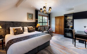 A hotel room with a large bed, a chandelier, a dining area, and a view of the outdoors. - Hana Lodge (Rotorua)