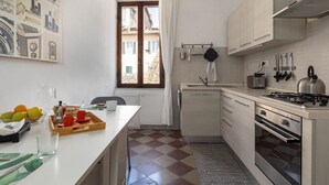 Une cuisine moderne avec un carrelage à motifs, une cuisinière et une fenêtre avec des rideaux.
