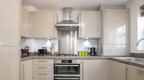 A modern kitchen with stainless steel appliances, a gas stove, and a built-in oven.