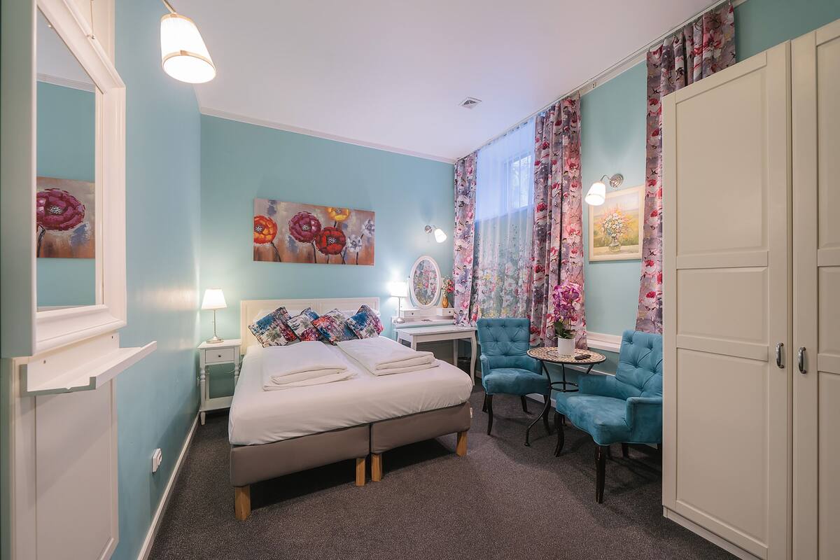 Une chambre à coucher avec un lit, un bureau, une chaise et une armoire.