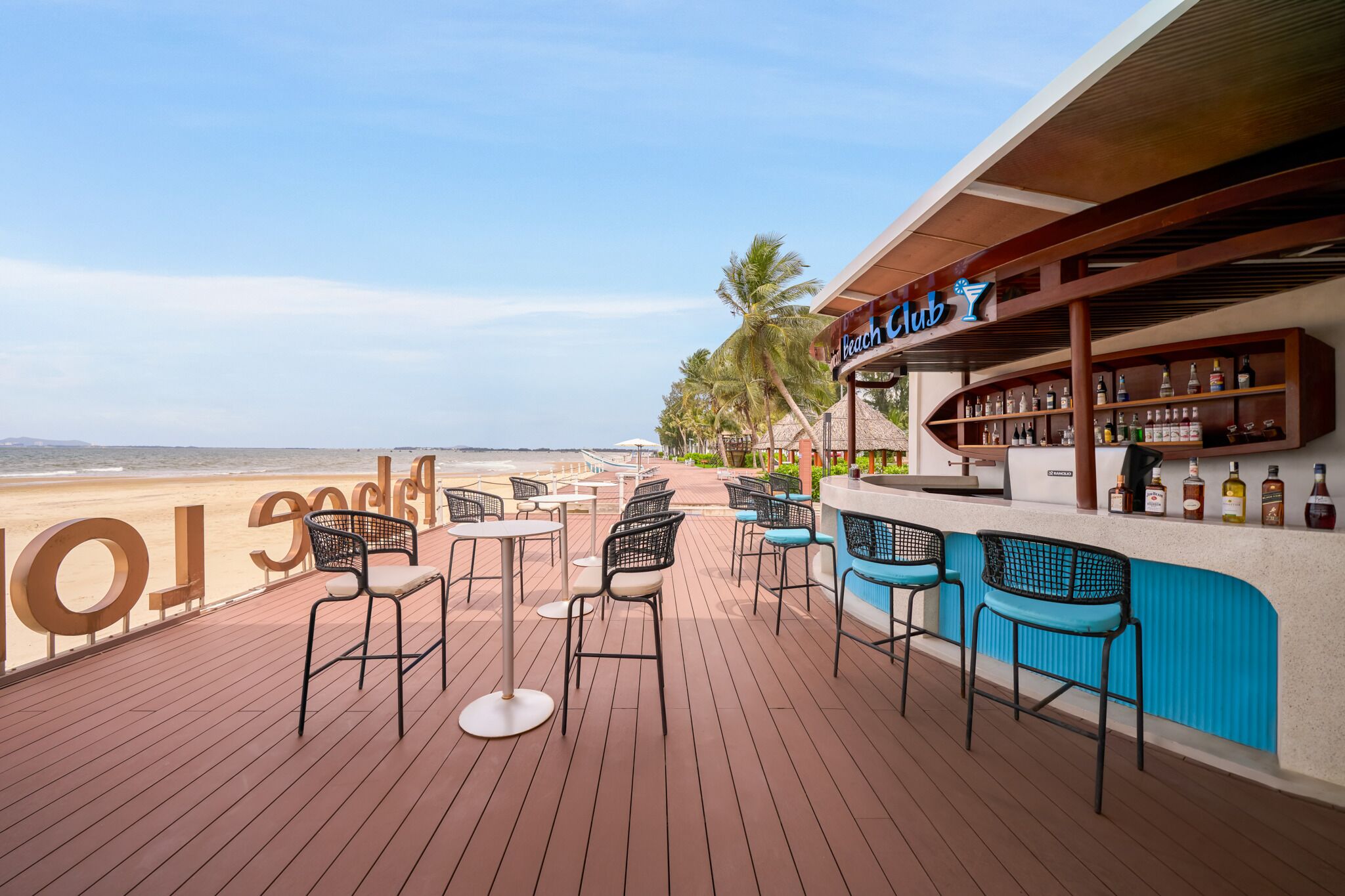 Un bar junto a la playa con terraza y vistas al océano.