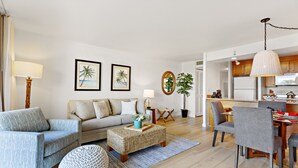 A modern living room with a sofa, armchairs, a coffee table, and a dining area with chairs and a table. - Tropical charm, ocean touches - A guest favorite (Lahaina)