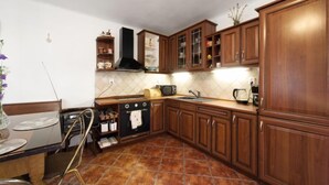 Une cuisine avec des meubles en bois, un pare-feu en carrelage et une cuisinière.