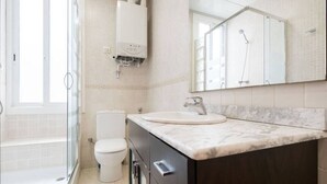 Ein Badezimmer mit Dusche, Toilette und Waschbecken.