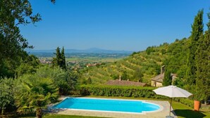 A swimming pool with a view of a town and hills in the background. - Il Farinaio by Interhome (Cortona)