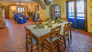 A dining area with a table set for four, surrounded by wooden chairs. - Il Farinaio by Interhome (Cortona)