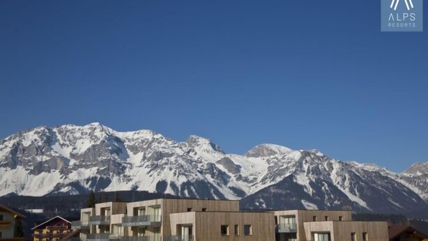 Un edificio moderno con montañas al fondo, probablemente un hotel o resort.
