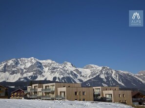 Un edificio moderno con montañas al fondo, probablemente un hotel o resort.