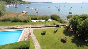 A marina with boats docked, a swimming pool, and a grassy area with benches.
