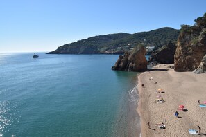 A beach with clear blue water, rocky cliffs, and a few people relaxing on the sand. - Mediterranean Villa 900m From the Beach! (Pals)