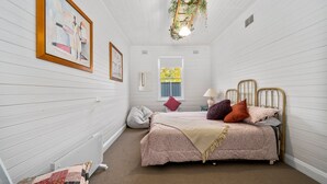 A bedroom with a bed, a window, a radiator, and wall-mounted artwork. - Olive Nook in Katoomba (Katoomba)