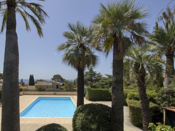 A swimming pool surrounded by palm trees and well-maintained hedges. - Le Bali by Interhome (La Ciotat)