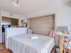 Een moderne hotelkamer met een groot bed, een kleine kitchenette en een eethoek.