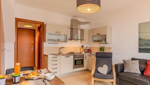 Un espacio habitable pequeño con kitchenette, comedor y zona de estar.