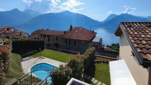 Zona residencial con piscina, vista a un lago y montañas al fondo.