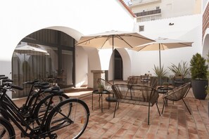 A patio area with bicycles, outdoor furniture, and potted plants.