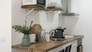 Een keuken met een houten aanrecht, een broodrooster, een spoelbak en een magnetron.