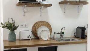 Een keuken met een houten aanrecht, een broodrooster, een spoelbak en een koffiezetapparaat.