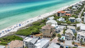 Zona residencial costera con propiedades frente a la playa, una playa de arena y una vista despejada del océano.