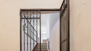 Una escalera con una reja de hierro forjado en la parte superior, que conduce a un espacio interior.