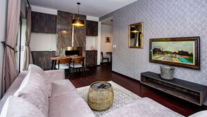 Un salon moderne avec un canapé, une table basse, un téléviseur et une cheminée.