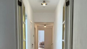A hallway with wooden flooring, white walls, and a radiator on the right. - At home in Oltrearno (Firenze)