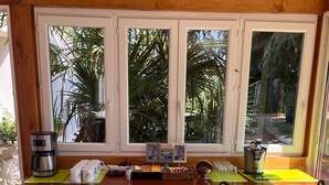Eine Küche mit einer Holzarbeitsplatte, einer Kaffeemaschine und einem Fenster mit Blick auf Grünflächen.