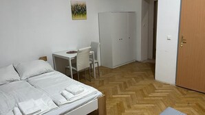 A bedroom with a bed, a desk, a chair, and a wardrobe.